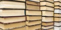 Books stack on wooden table and blurred bookshelf in library hall. Royalty Free Stock Photo