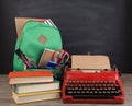 Education concept - school backpack with books and other supplies, blackboard background Royalty Free Stock Photo