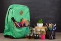 Education concept - school backpack with books and other supplies, blackboard background Royalty Free Stock Photo