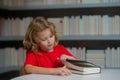 Education Concept. Schoolboy reading book in library. Kids learn to read. Pupil reading books in a school library Royalty Free Stock Photo