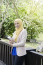 Muslimah woman standing and holding notebooks