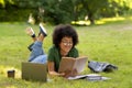 Education Concept. Smiling African American Student Girl Reading Book While Studying Outdoors Royalty Free Stock Photo