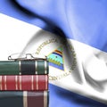 Education concept - Stack of books and reading glasses against National flag of Nicaragua