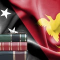 Education concept - Stack of books and reading glasses against National flag of Papua New Guinea