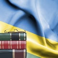 Education concept - Stack of books and reading glasses against National flag of Rwanda