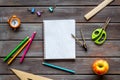 Education concept with stationery of student with notebook, pens, clock on wooden background top view