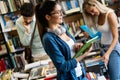 Education concept. University students preparing for exam, talking in library Royalty Free Stock Photo