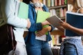 Education concept. University students preparing for exam, talking in library Royalty Free Stock Photo