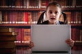 Education concept. Young beautiful child girl working  with laptop and reading books in library. Horizontal image. Copy space Royalty Free Stock Photo