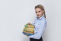 Education Concepts. Portrait of Caucasian Blond Female Posing With Heap of Books in Colorful Covers Against White