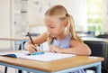 Education, drawing and girl in classroom learning, exam or studying with book. Preschool, development and serious kid Royalty Free Stock Photo