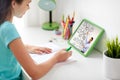 Girl with tablet pc writing to notebook at home Royalty Free Stock Photo