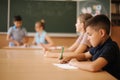 Education, elementary school. Learning and people concept - group of school kids with pens and notebooks writing test in Royalty Free Stock Photo