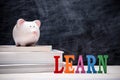 Education financial saving. Pink Piggy bank on top of books with Royalty Free Stock Photo