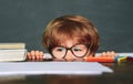 Education first. Funny little boy pointing up on blackboard. School and education concept. Little children at school Royalty Free Stock Photo