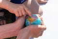Education in Global world, child use pocket globe to show where his country is. study of political map of world on globe