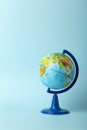 Education and globalism concept. Globe on an open book on a table in a university class on a blue background