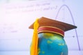 Education Graduate study international concept: Graduation cap on top Earth globe model map with formula equation graph on screen