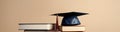 Education Graduation cap on a beige background on a stack of books Royalty Free Stock Photo