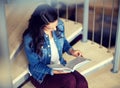 High school student girl reading book on stairs Royalty Free Stock Photo