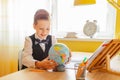 Education at home concept - Cute little boy studying or completing home work on study table with a globe and workbook