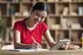 Education at home and new app. Cheerful young asian girl student doing homework with tablet, watch online lesson Royalty Free Stock Photo