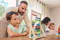 Education, home school and father with his child with abacus helping him work on math homework. Study, knowledge and Royalty Free Stock Photo