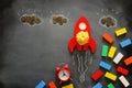 Education or innovation concept. Wooden rocket over blackboard background. top view