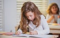 Education, learning and children concept. Little student girl pupil with book writing school test. Back to school. Happy Royalty Free Stock Photo