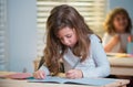 Education, learning and children concept. Little student girl pupil with book writing school test. Back to school. Happy Royalty Free Stock Photo