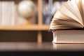 Education learning concept. Book in library with old open textbook, stack piles of literature text archive on reading desk, aisle