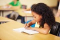 Education, learning and girl in a classroom, writing and focus with notes, book and homework. Female child, student and