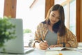 Education and literacy concept, College student girl using laptop and doing homework in library Royalty Free Stock Photo