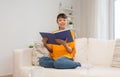 Smiling young asian woman reading book at home Royalty Free Stock Photo