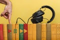 Education and modern technologies. The concept of audio books and media players. Vintage books are in a row, they are headphones. Royalty Free Stock Photo