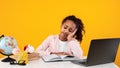 Tired black girl sitting at desk and reading book Royalty Free Stock Photo