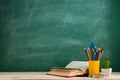 Education and reading concept - group of colorful books on the wooden table in the classroom, blackboard background