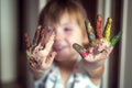 Education, school, art and painitng concept - little girl showing painted hands