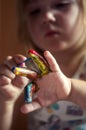 Education, school, art and painitng concept - little girl showing painted hands Royalty Free Stock Photo