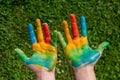 education, school, art and painitng concept - little student girl showing painted hands at school on grass Royalty Free Stock Photo