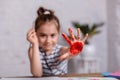 Education, school, art and painting concept - smiling little student girl showing painted hands at school Royalty Free Stock Photo