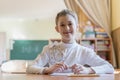 education and school concept - little student girl writing in notebook at school Royalty Free Stock Photo