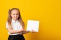 Education and school concept. Smiling little student girl with book. Copy space. Little kid looking at mockup poster Royalty Free Stock Photo