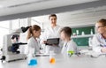 Teacher with tablet pc and kids at chemistry class