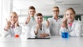 Happy kids showing thumbs up at school laboratory