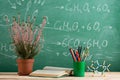 Education and sciences concept - bookand molecule model on the desk in the auditorium, photosynthesis formulas on the background