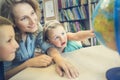 Education. Side view of little kids pointing at globe in classro