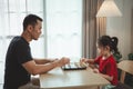 Education studying concept. Little cute asian baby girl children playing chess with her father dad in the living room at home. Royalty Free Stock Photo