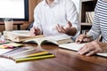 Education, teaching, learning concept. Two high school students or classmates group sitting in library with helps friend doing Royalty Free Stock Photo