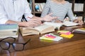 Education, teaching, learning concept. Two high school students or classmates group sitting in library with helps friend doing Royalty Free Stock Photo